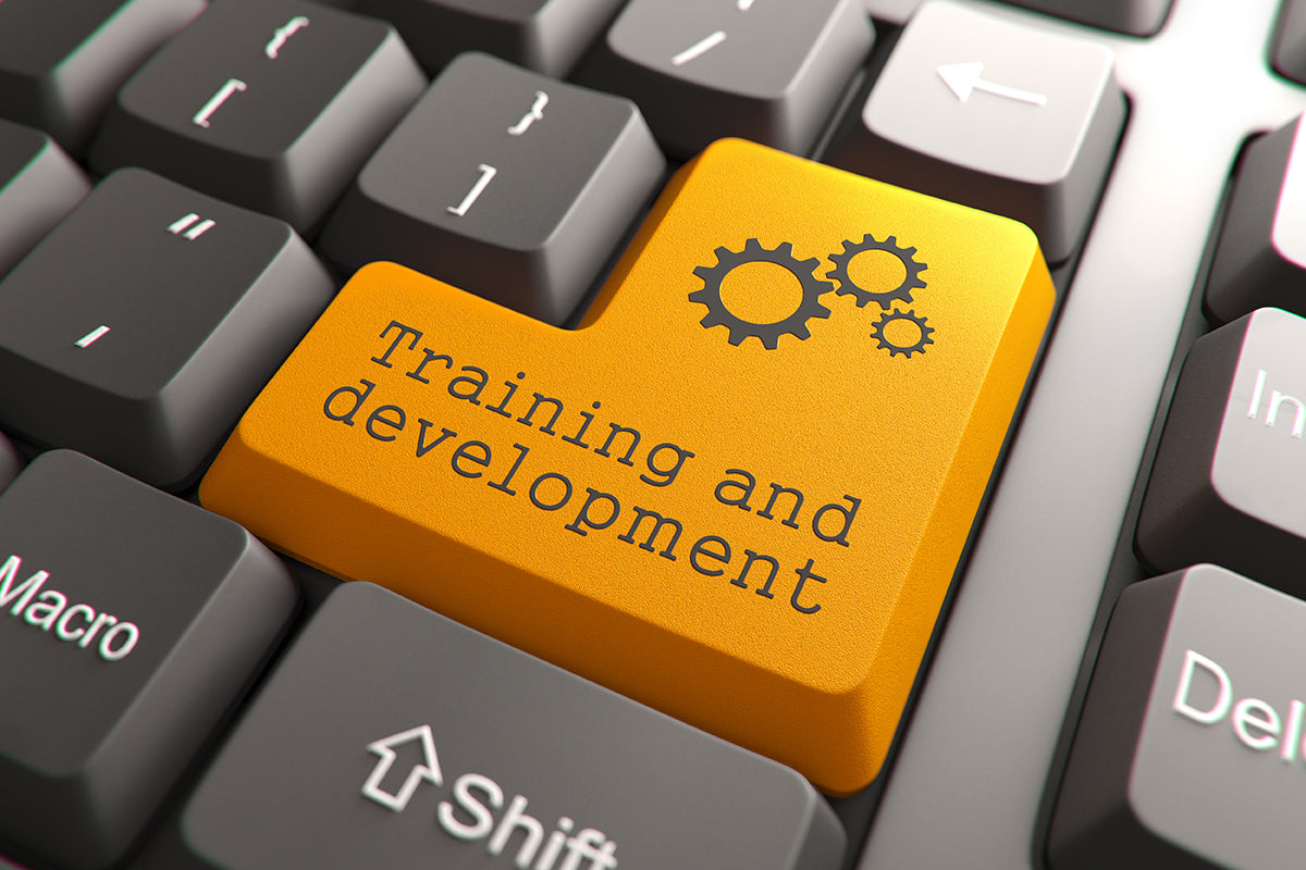 Keyboard with a yellow 'Training and development' key featuring gear icons.
