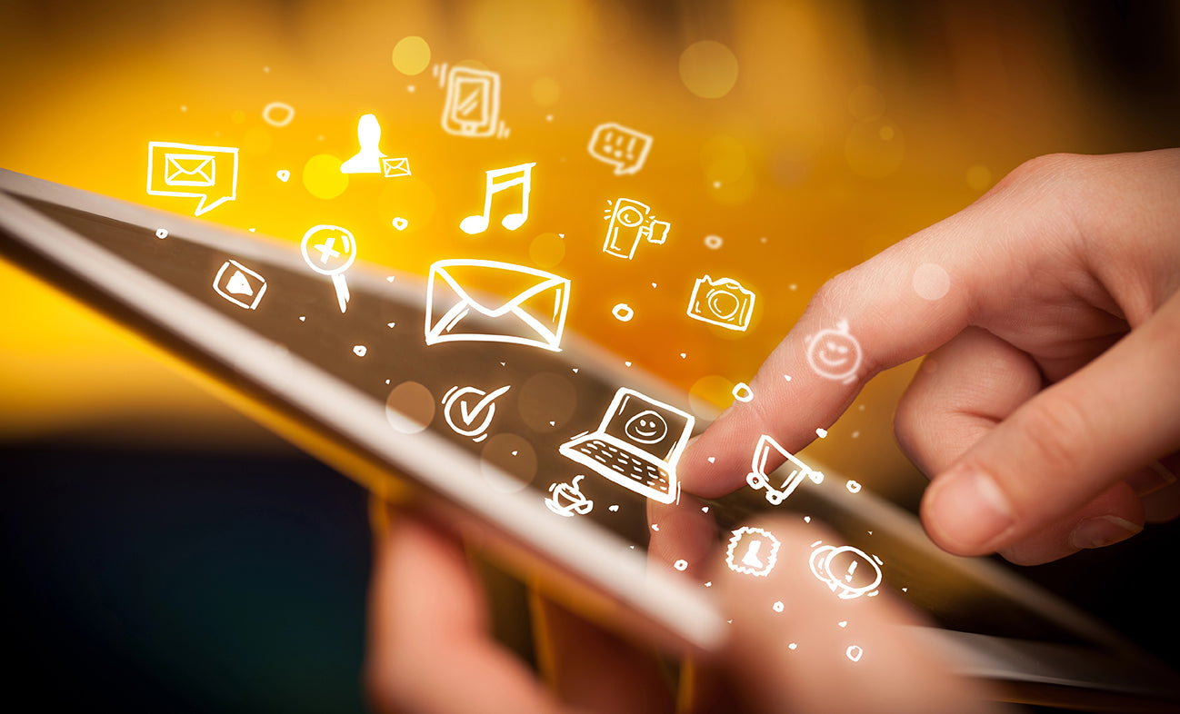 Hand using a tablet with digital icons on a blurred background