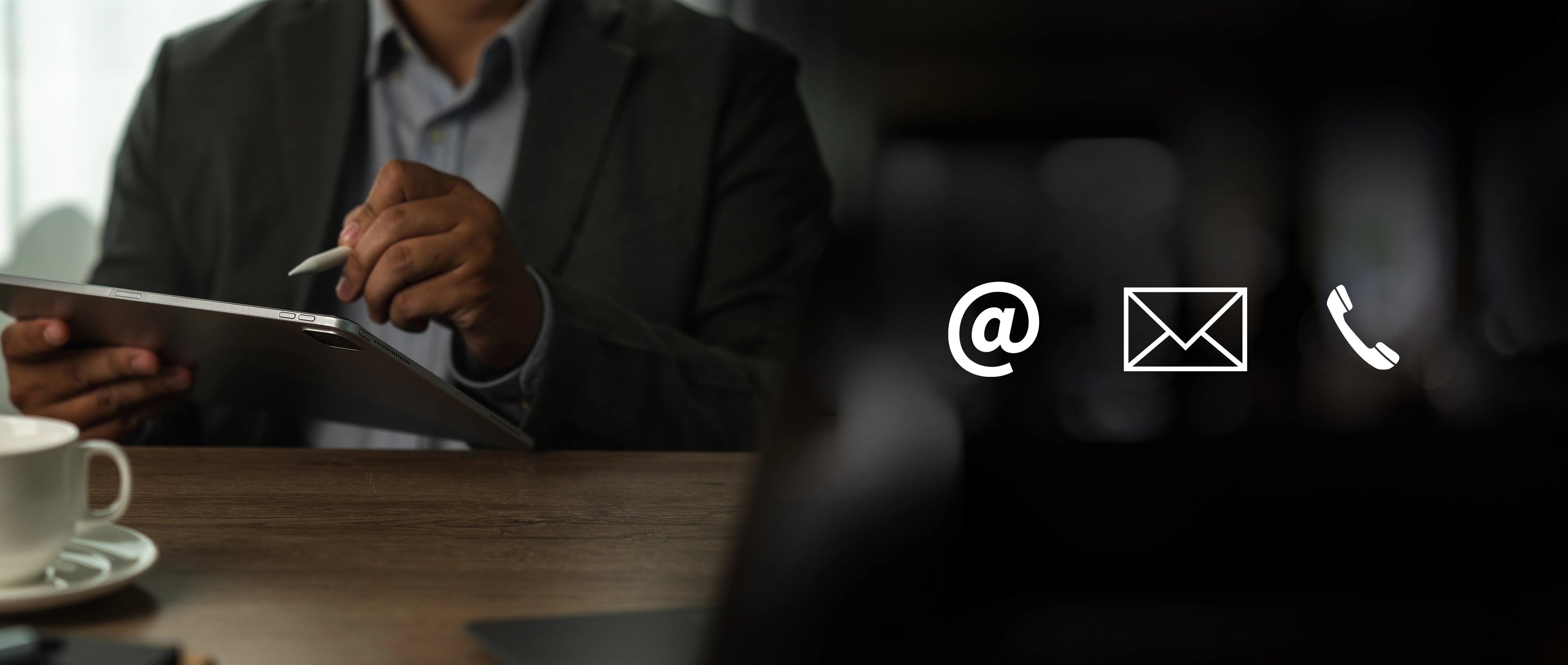 Person using a tablet with contact icons overlayed on a blurred background