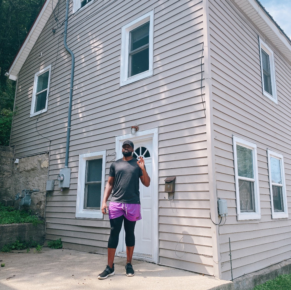 Person standing outside a house wearing athletic gear